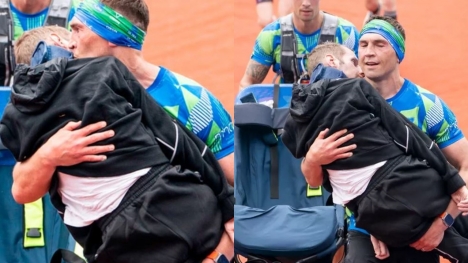 Man carries former teammate sitting in wheelchair to marathon finish line