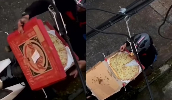 Pizza delivery rider caught tucking into slice before deftly jigsaw-ing the rest back together with a knife