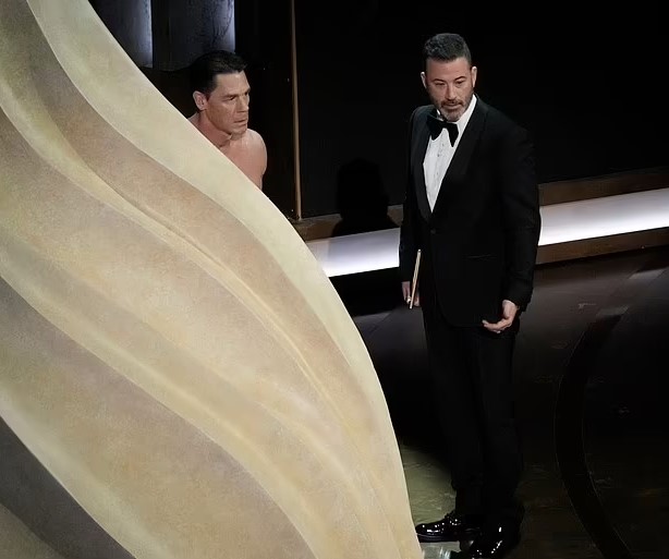 The actor hides behind the stage curtain before appearing with his unexpected look. Image Credit: Getty