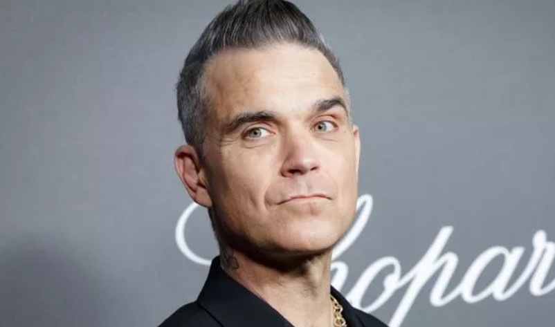 Robbie Williams, the famous British singer, believes aliens target him due to his celebrity status, seeking his help. Image Credit: Getty