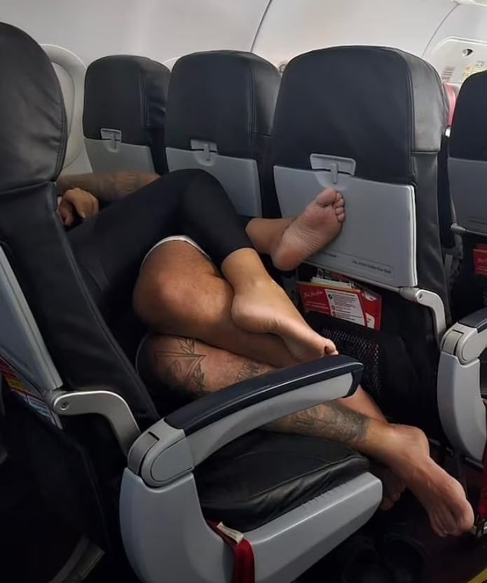 Passengers baffled as couple get intimate while lying down across a row of seats barefoot during flight 4