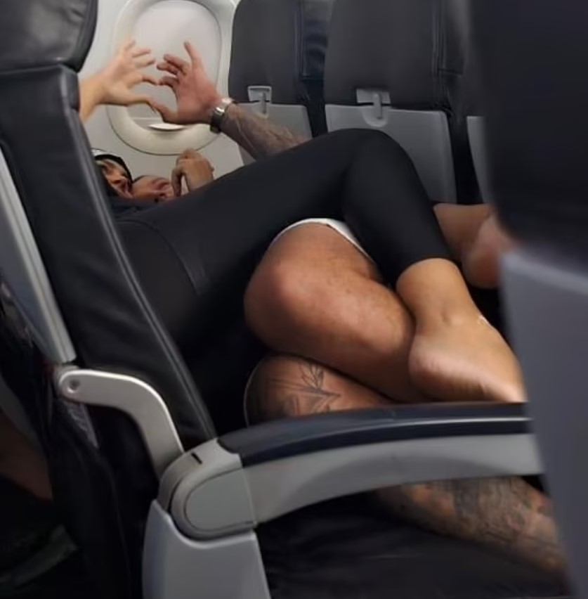 Passengers baffled as couple get intimate while lying down across a row of seats barefoot during flight 3