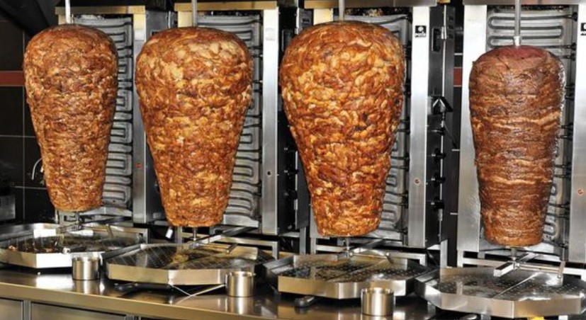 Doner kebab, a beloved global street food, involves stacking and roasting thinly sliced meat on rotisserie. Image Credit: Getty