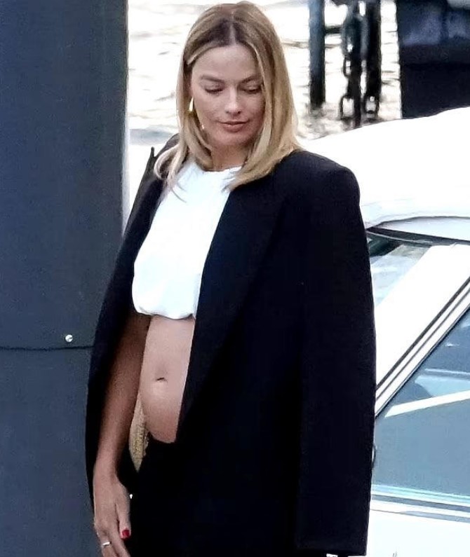 Robbie's pregnancy confirmed by sources after a photo revealed her noticeable baby bump during a leisurely walk. Image Credit: BackGird