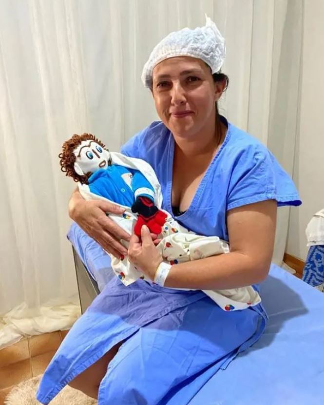 Woman who just gave birth to her first child with a rag doll. Image: @meirivone_santinha Instagram