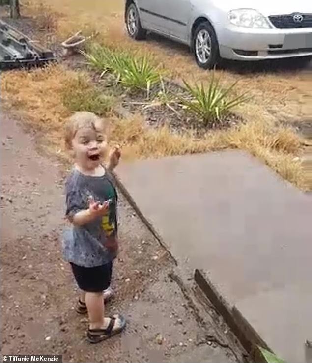 An 18-month-old boy sees rain for the first time in his life, dances with joy and splashes in puddles 2