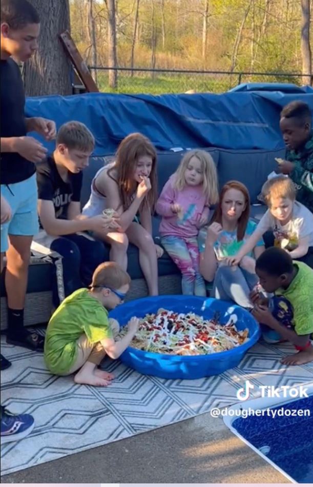 A mother serves a meal to 12 children in a baby pool 4