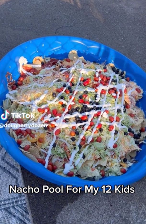 A mother serves a meal to 12 children in a baby pool 3