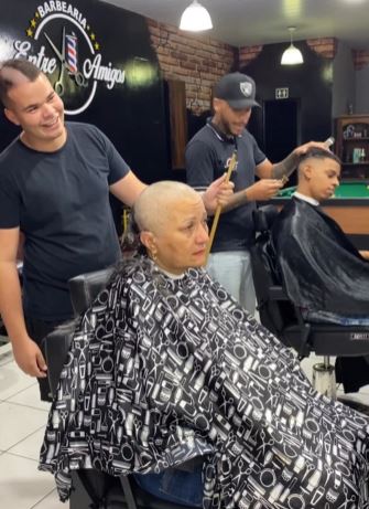 Internet in tears as barber shaves head in support of mother's cancer battle 3