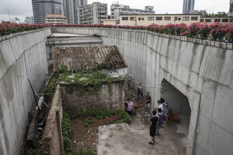 Unyielding house gets wedged between surrounding highway bridge 2