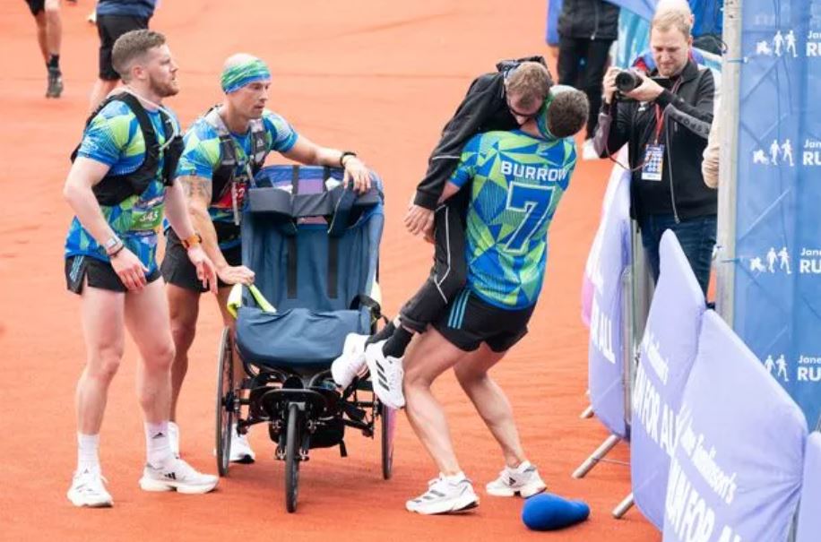 Man carries former teammate sitting in wheelchair to marathon finish line 1