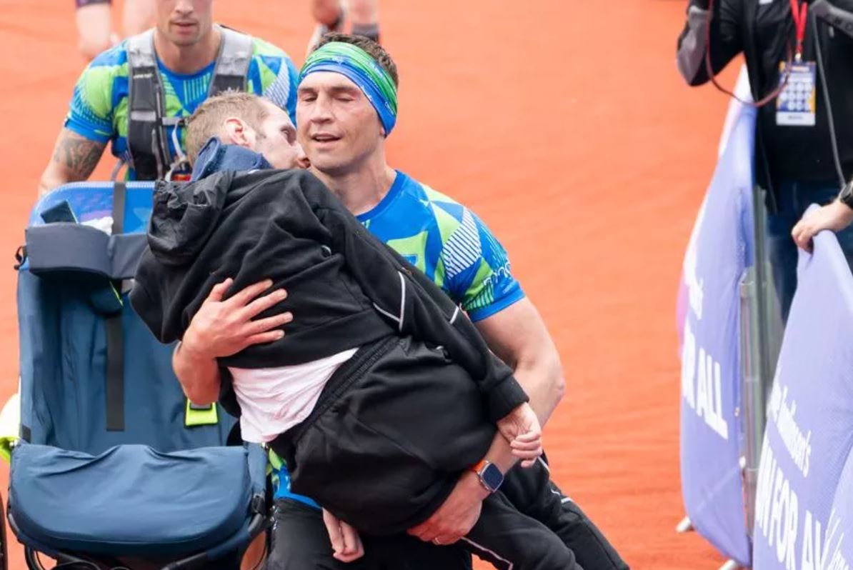 Man carries former teammate sitting in wheelchair to marathon finish line 2