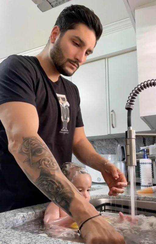Father is criticized for putting his baby in the kitchen sink and bathing the baby while washing dishes 1