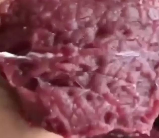 After the video, the butcher carefully places the spasming meat back onto the surface. Additionally, a close-up shot showcases the spasming meat, generously coated in salt.