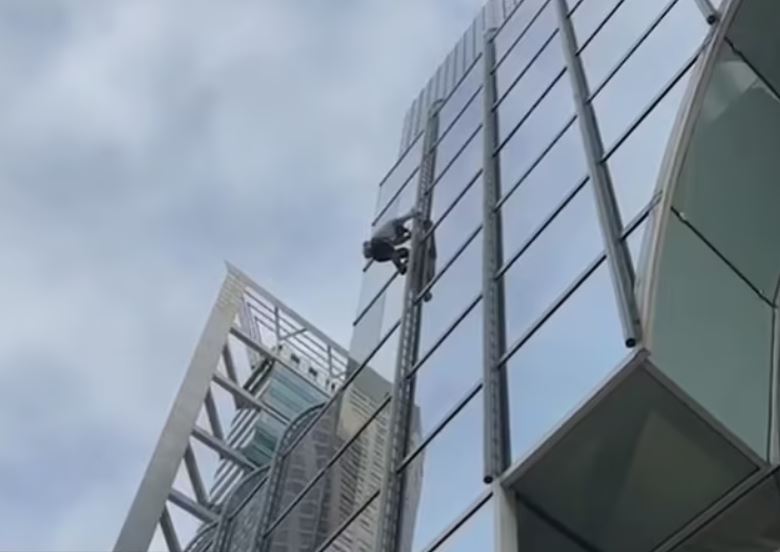 Office workers stunned as 'Pro-life Spiderman' climbs15th-floor window without a rope 3