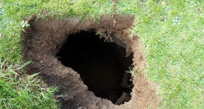 Family baffled after spotting rusty steps lead to mysterious 7ft-deep hole in their lawn 3