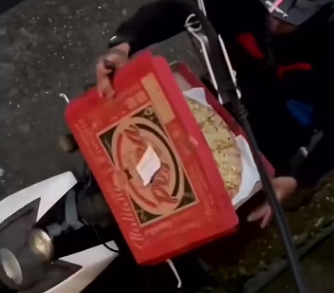 Pizza delivery rider caught tucking into slice before deftly jigsaw-ing the rest back together with a knife 1