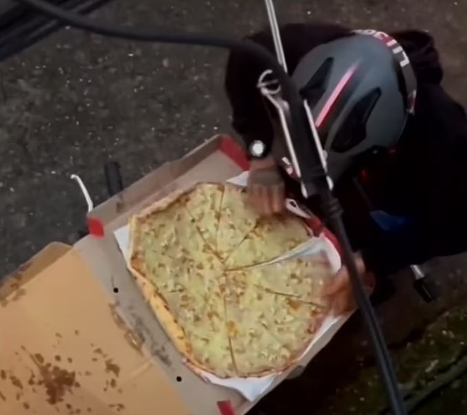 Pizza delivery rider caught tucking into slice before deftly jigsaw-ing the rest back together with a knife 2