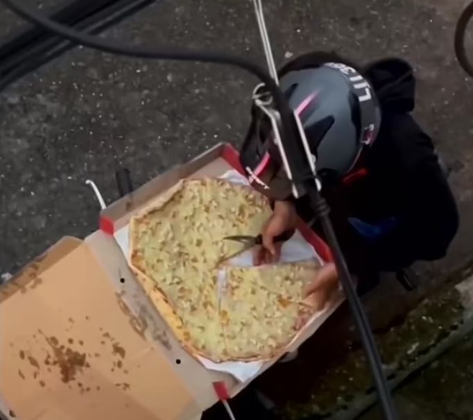 Pizza delivery rider caught tucking into slice before deftly jigsaw-ing the rest back together with a knife 3