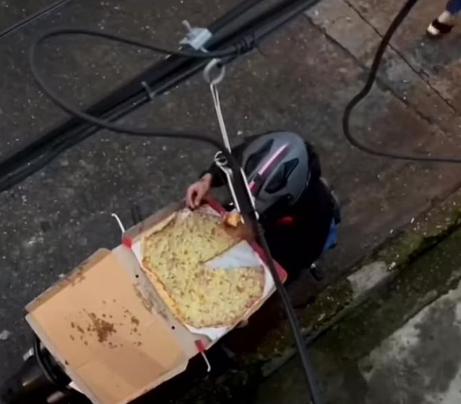 Pizza delivery rider caught tucking into slice before deftly jigsaw-ing the rest back together with a knife 5