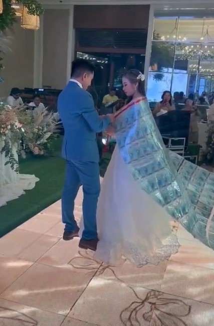 Groom drapes crash sheet with $17,000 over bride's shoulder at wedding  3