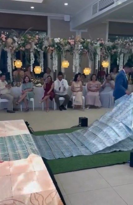 Groom drapes crash sheet with $17,000 over bride's shoulder at wedding  1