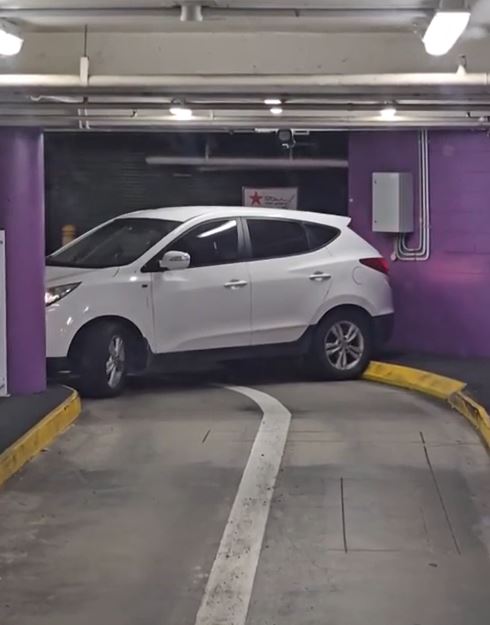 Driver struggles to escape with car trapped in shopping center 2